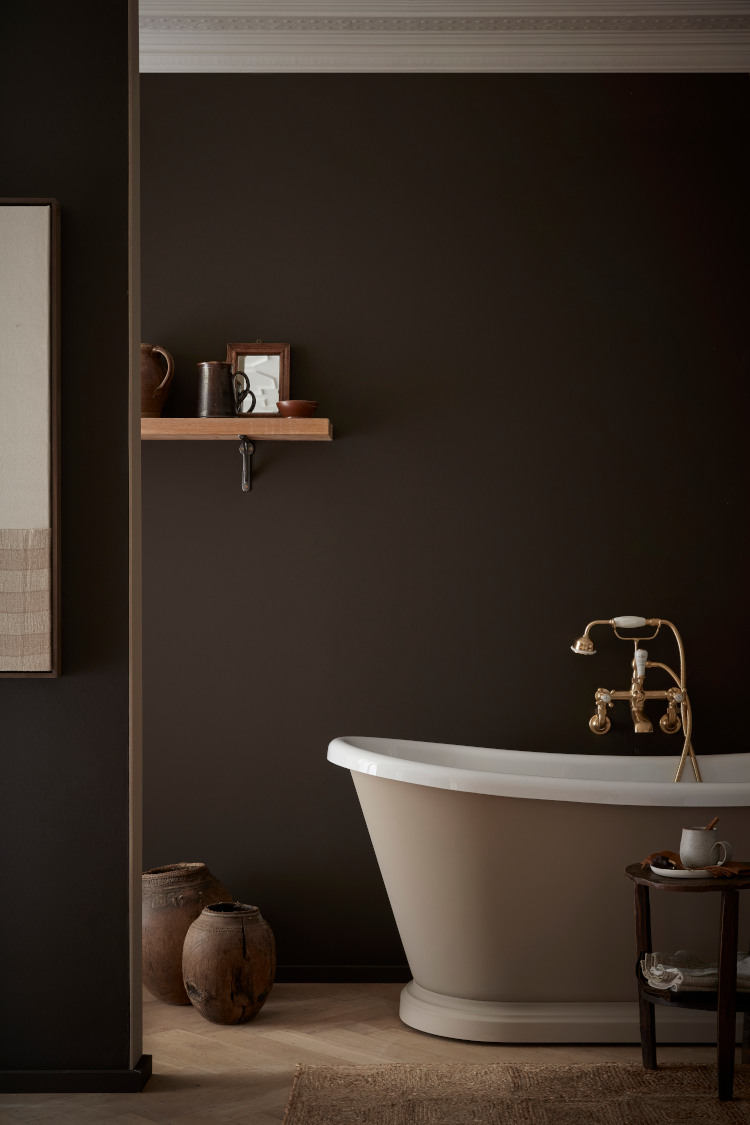 A luxurious bathroom with rolltop bath and traditional copper taps is painted in Little Greene Chocolate Colour Paint.