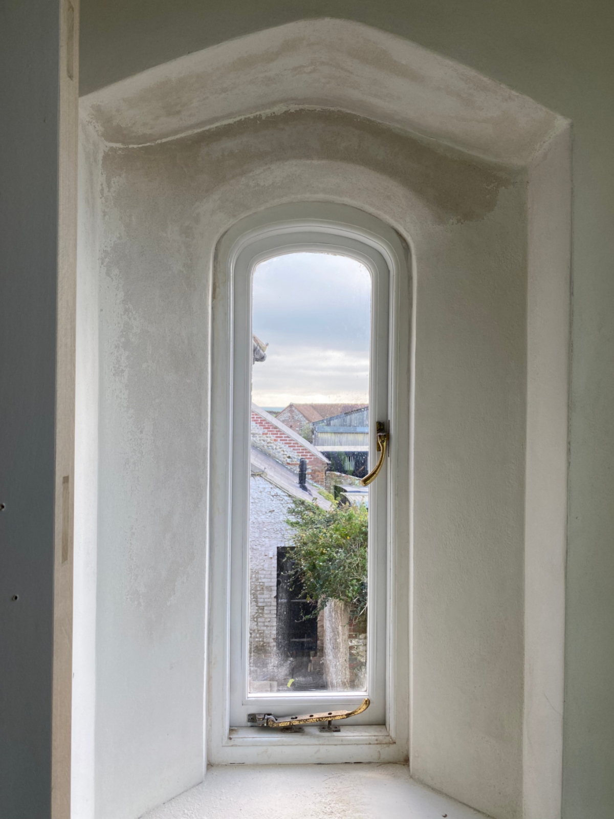 A historic white coloured arrow slit window. Part of the 15th Century Manor interior design project.