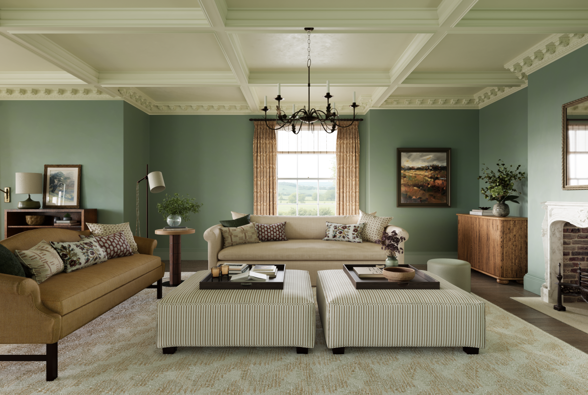 Drawing room showing classic duck egg blue walls and warm layered fabrics with panelled ceiling and fireplace