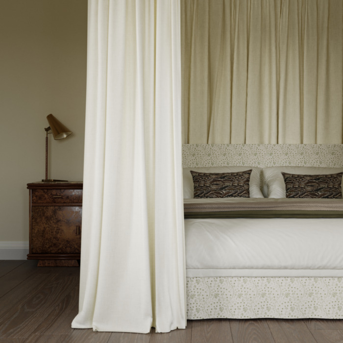 A close up image of the bed in the master bedroom of the The ground floor floor plan of the Sussex Estate Interior Design project showing a large white fabric canopy alongside a dark wooden bedside table and lamp.