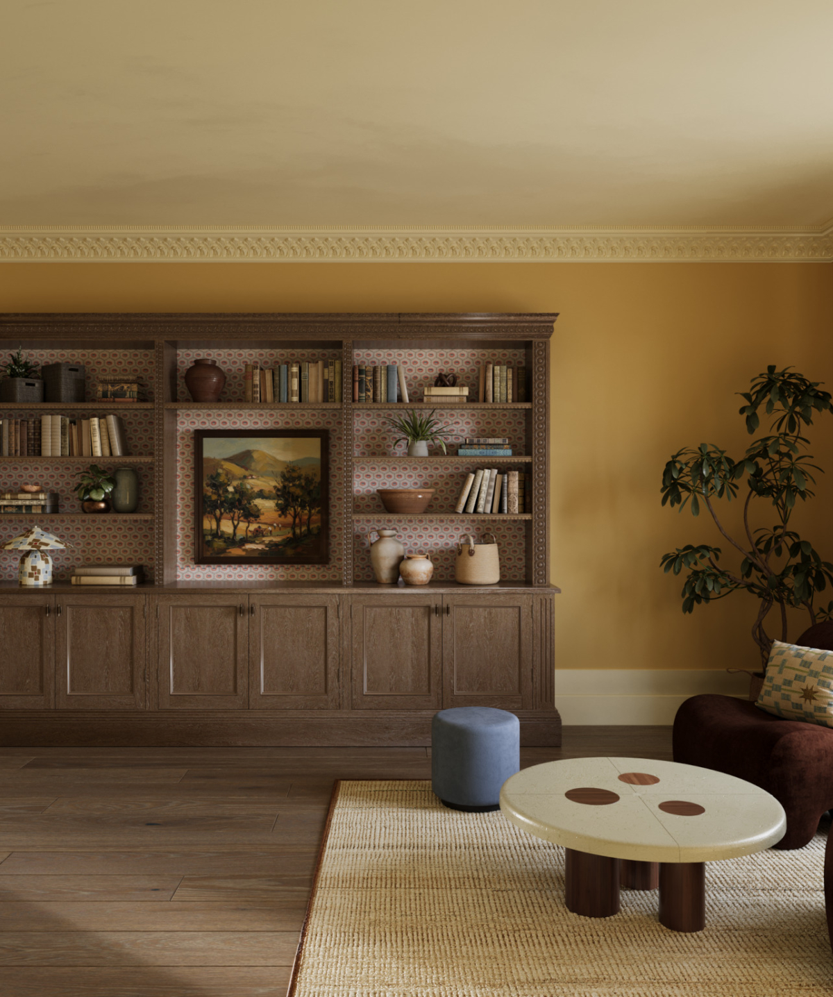 Custom shelving is installed in the games room of the Sussex Estate Interior design project for books and pictures in an ochre coloured room complete with rug, side table and ottoman.