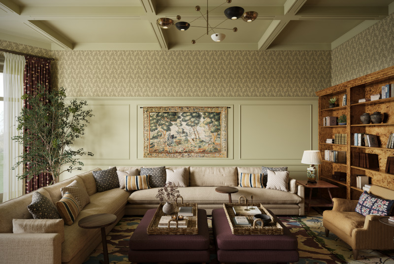 The hero image for the Queen Anne Interior Design project from Studio Hooton of Mayfair. An very large living room soft neutral panelled and wallpapered walls showcase a large taupe wraparound sofa. In the middle are two large burgundy coloured pouffes with trays. To either side are large red patterned curtains and a large wooden bookcase showcasing a modern English country property.