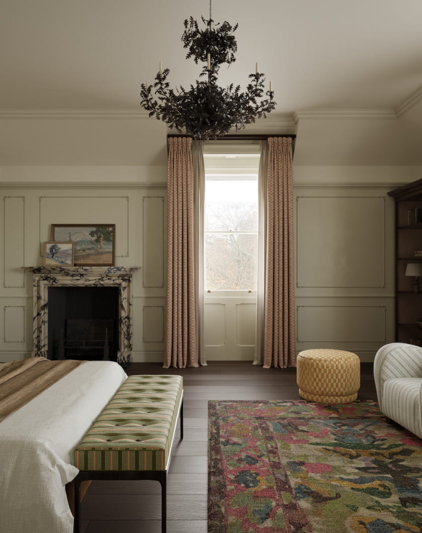 A elegant historic country property bedroom shows a large bed, large rug, marble fireplace and floor to ceiling window which gives off a diffused white light. Suspended from the ceiling is a large black metal floral chandelier. Used to demonstrate full service interior design as part of Studio Hooton's interior design services.