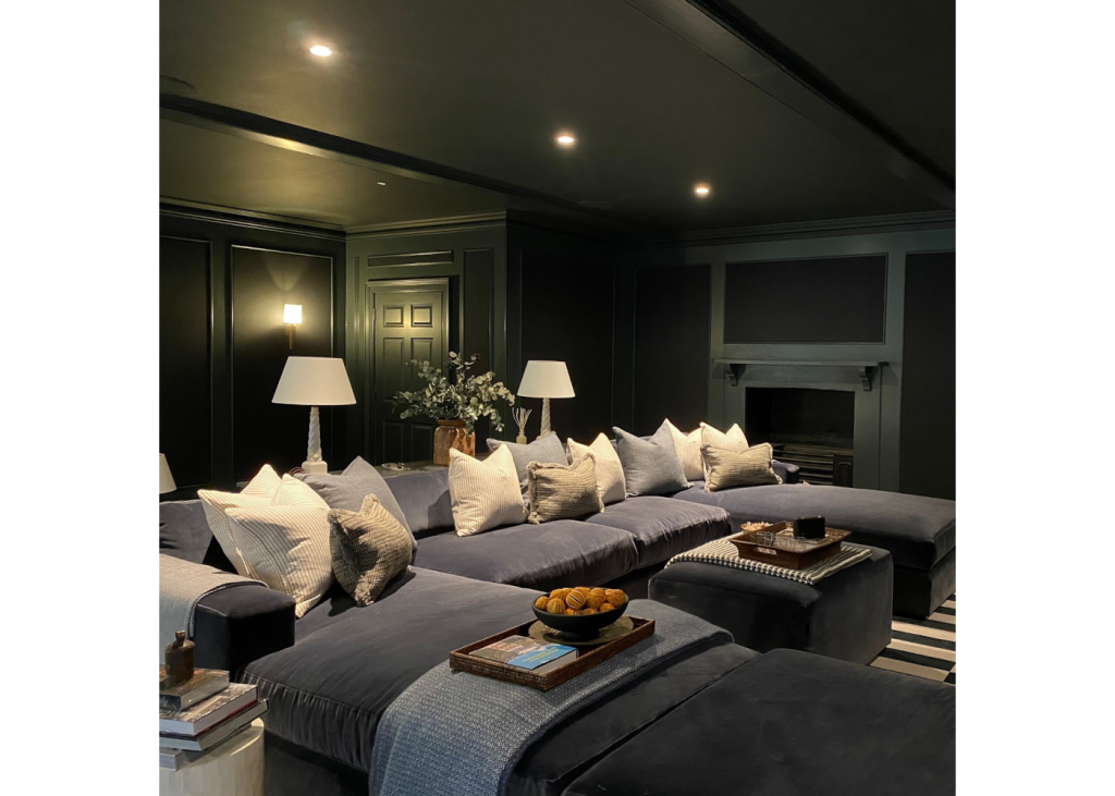 Luxury bespoke home cinema room with u shaped sofa, numerous white and grey cushions with various table lamps and spotlights designed by Albion Nord.